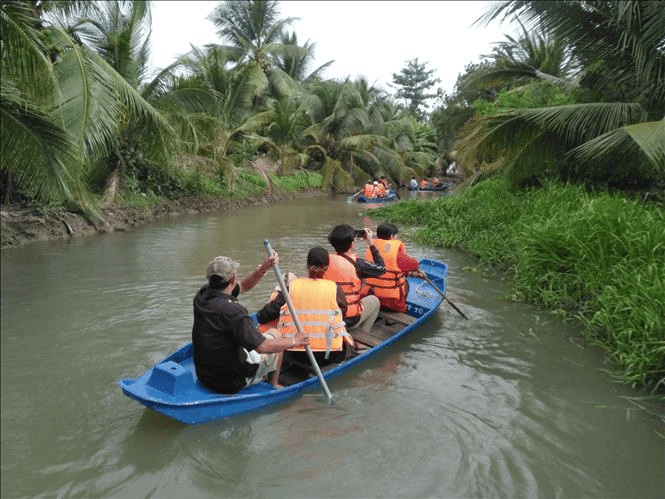 Du khách trải nghiệm hoạt động tự bơi xuồng trên sông trong Nông trại dê sữa du lịch Đông Nghi.